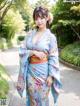 A woman in a blue kimono posing for a picture.