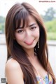 A woman with long brown hair posing for a picture.