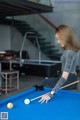 A woman is playing a game of pool. 