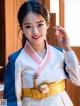 A woman in a white and blue hanbok posing for a picture.