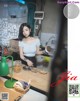 A woman standing in a kitchen holding a cup of coffee.