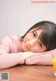 A woman laying on a table next to a glass of orange juice.