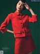 A woman in a red suit posing for a magazine.