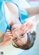 A woman laying on the floor with her hands on her face.